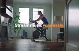 Looping video of a woman using Google Assistant while riding a stationary bike