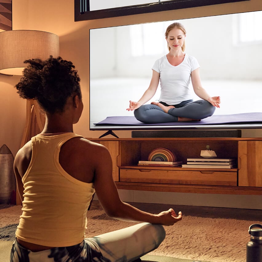 woman doing yoga on tv